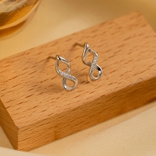 Detailed macro view of S925 sterling silver infinity symbol earrings with shimmering stones