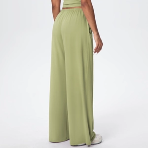 Detail showing high-waisted elastic waistband on green wide-leg draped lounge pants