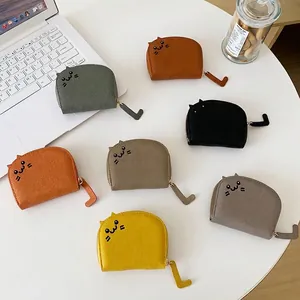 Cute cat-shaped mini card wallets with tail zipper in multiple colors on a desk