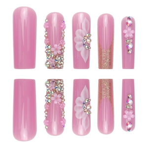 Long coffin press-on nails in soft pink with 3D floral accents and sparkling rhinestones