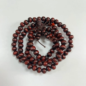 Macro view of 8mm sandalwood Buddhist beads with distinct wood grain and knot detail