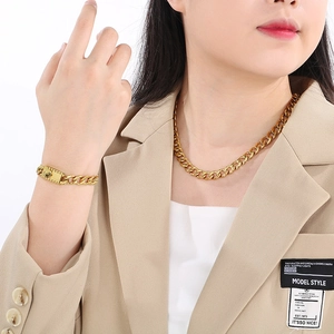 Close-up of gold Figaro chain necklace and bracelet with box clasp on male model