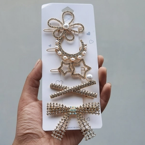 Detailed set of 5 gold hair clips featuring pearls, rhinestones, and floral star motifs