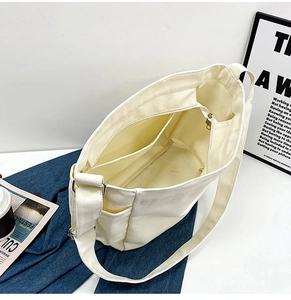 Interior view showing the zipper pocket and internal storage of the white canvas tote bag