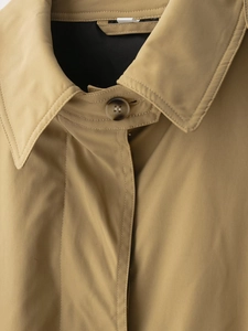 Gros plan du col d'un trench-coat kaki avec bouton haut de gamme à effet marbré