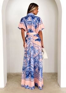 Detail of pink floral maxi dress with ruffle collar and waist belt in an alcove