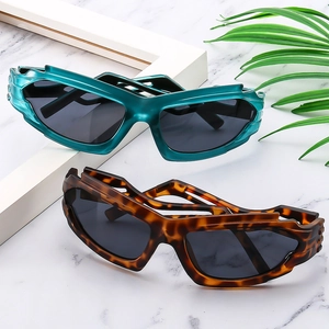 Gafas de sol de ciclismo futuristas Y2K en carey y verde azulado sobre fondo de mármol