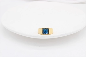 Detailed close-up of a gold titanium ring featuring a square blue gemstone inlay