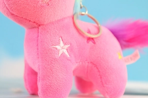 Dettaglio del portachiavi unicorno in peluche rosa con anello e stella ricamata