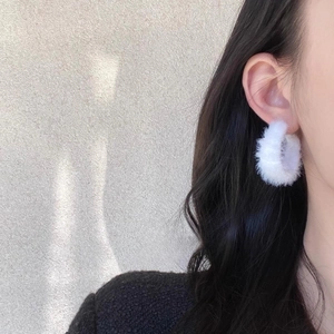 Vue détaillée de boucles d'oreilles blanches en peluche en forme de C sur un mannequin