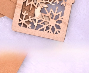 Detailed back view of laser-cut wooden Christmas ornament with snowflake and deer motifs