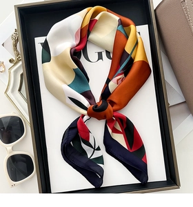 Detail of silk scarf with abstract floral patterns and elegant color-blocking texture