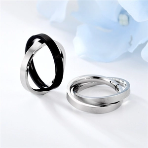 Macro detail of interlocking matte silver and black titanium steel fidget rings on white
