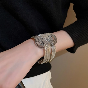 Macro shot of silver woven knot multilayer open cuff bracelet with mesh texture