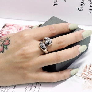 Detailansicht eines minimalistischen silbernen Edelstahlrings mit doppeltem Tropfendesign