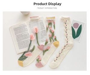 Close-up of three sheer tulle socks with pink tulip embroidery and colorful accents