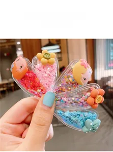 Detailed view of five colorful heart-shaped hair clips with sequins and cartoon girl decor