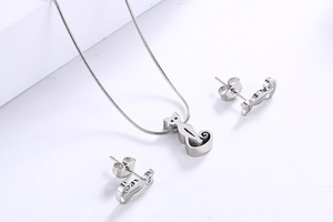 Detail view of silver kitten necklace and stud earrings set on a clean white background