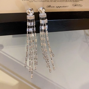 Macro shot of silver tassel earrings featuring long cascading rhinestones and a top stud