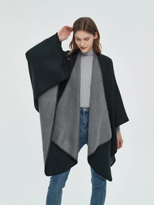 Detail view of a black and grey split color block knit shawl with decorative stitching