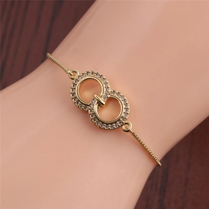 Detail of adjustable gold woven bracelet with interlocking micro-pave zircon rings on wrist