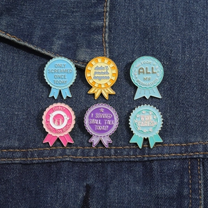 Detailed set of six colorful metal enamel award pins on dark blue denim fabric