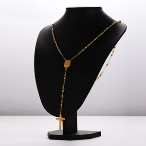 Polished gold stainless steel rosary necklace with cross and saint medal on a neck display