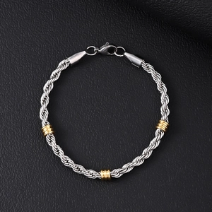 Detailed view of silver and gold twisted rope bracelet with lobster clasp on black background