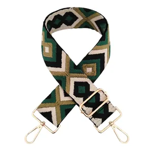 Detail of wide ethnic strap with green geometric jacquard weaving and gold metal hooks