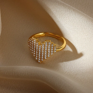 Detailed macro view of gold heart ring with micro-paved zircons on beige silk