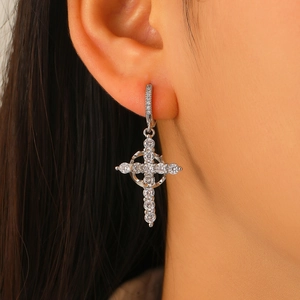 Macro shot of silver cross drop earrings with pavé white zircons worn on model