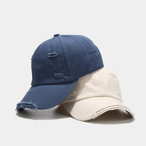 Vintage distressed baseball caps in navy and beige showing worn-out street style detail