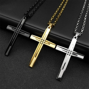 Trois pendentifs croix évidés en noir, or et argent sur des chaînes en métal chic
