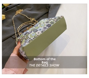 Detail view of the floral handbag bottom with green material and gold metal chain