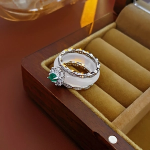 Macro shot of stacking rings with green gemstone and white agate in a wooden box