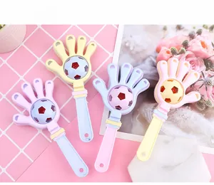 Macro detail of macaron-colored hand clapper baby rattles with soccer ball accents
