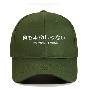 Detail der armee-grünen Baumwoll-Basecap mit weißem Stickerei-Schriftzug Nothing Is Real