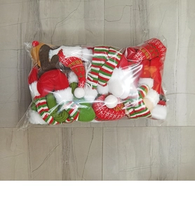 Close-up of bulk plush Christmas ornaments packaged in clear plastic bags on a tile floor