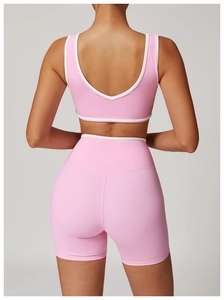 Vue arrière de l'ensemble de yoga rose avec découpe au dos et détails de liseré blanc