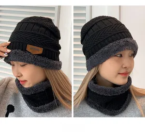 Detail of winter knitted beanie hat with warm thick fleece lining and neck warmer set