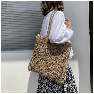 Detailed view of woven hollow flower pattern on a beige handmade straw tote bag