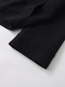 Detailed close-up of premium wool blend fabric and stitching on black jacket cuff