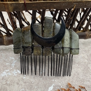 Close-up of natural labradorite stones and black crescent moon on a handmade hair comb
