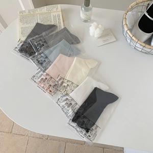 Set of mesh crew socks with ruffle edges in multiple colors on a minimalist white table
