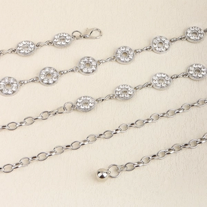 Detail of silver rhinestone waist chain with polished metal links and lobster clasp