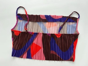 Macro detail of high-elastic pleated fabric with colorful geometric print on crop top