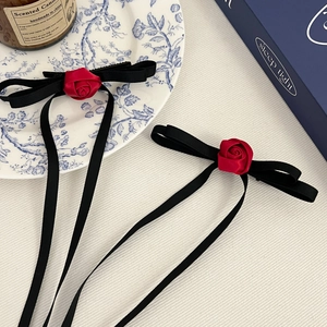 Elegant pair of black ribbon bow hair clips with red roses and long flowing streamers