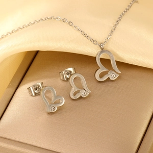 Silver stainless steel heart necklace and earring set with crystals on silk background