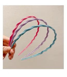 Detail showing wavy candy-colored plastic headbands with non-slip teeth for secure grip