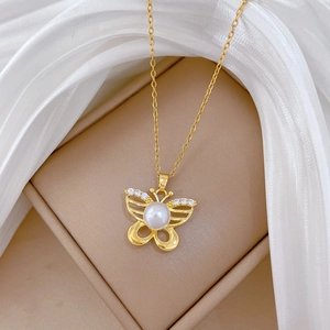 Elegant gold butterfly necklace with crystal inlay and white pearl pendant on a gold chain